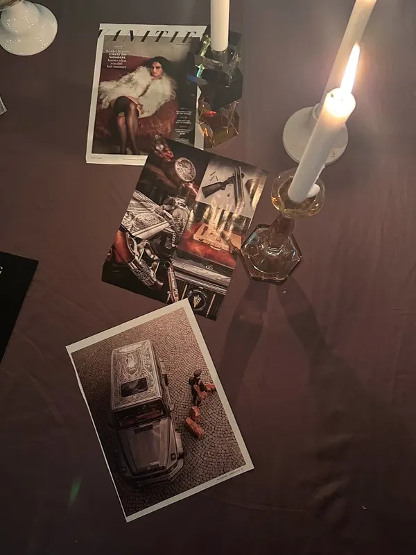 A candlelit table dressed with vintage fashion magazines and photographs