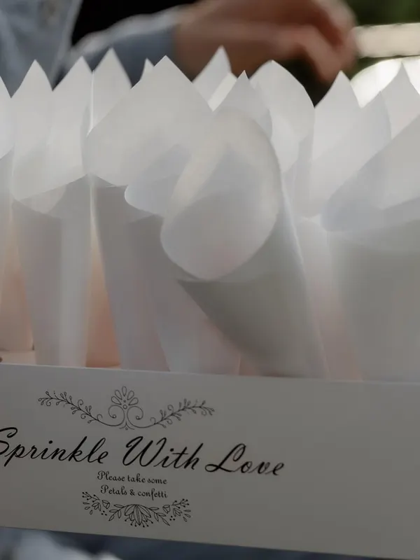 Paper cones for a petal toss in a box labeled Sprinkle With Love